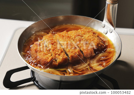 Katsudon being cooked in a pot 100053482