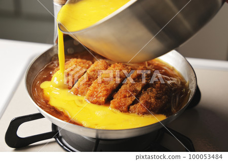 Katsudon being cooked in a pot 100053484