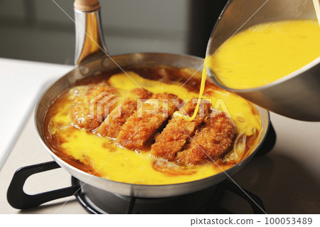 Katsudon being cooked in a pot 100053489