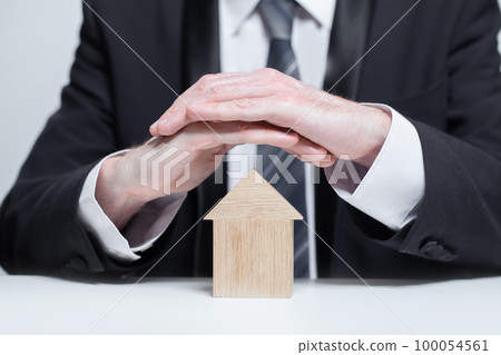 Wooden house under businessman hands protection, insurance safety property concept Wooden house under businessman hands protection, insurance safety property concept 100054561