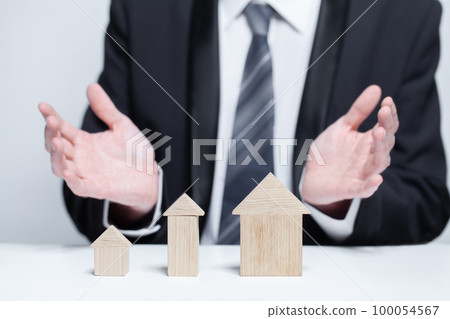 Wooden house models and businessman hands, byuing property, security, insurance concept 100054567