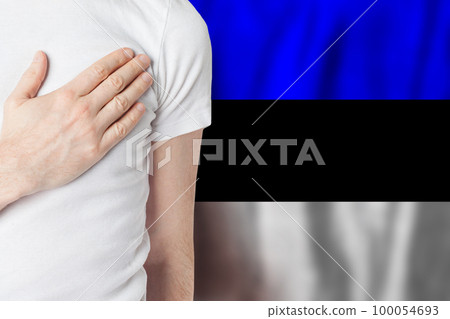 Estonian person with hand on heart on the background of Estonia flag. Patriotism, country 100054693