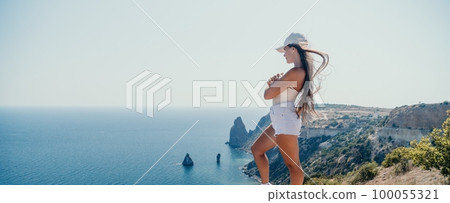 Woman summer travel sea. Happy tourist enjoy taking picture outdoors for memories. Woman traveler posing over sea bay surrounded by volcanic mountains, sharing travel adventure journey Woman summer travel sea. Happy tourist enjoy taking picture outdoors for memories. Woman traveler posing over sea bay surrounded by volcanic mountains, sharing travel adventure journey 100055321