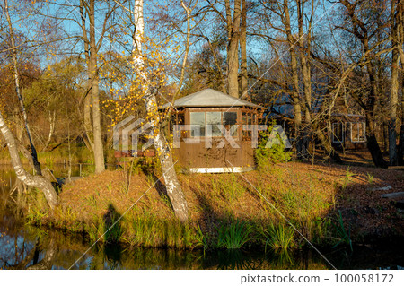 Pond with a little island and a gazebo in the evening Pond with a little island and a gazebo in the evening 100058172