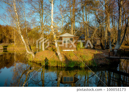 Pond with a little island and a gazebo in the evening Pond with a little island and a gazebo in the evening 100058173
