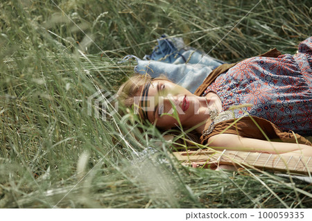 hippie woman lying on grass photo with copy space. 100059335