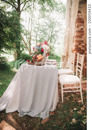 Decorated wedding table with candles in the garden. Decorated wedding table with candles in the garden. 100059410