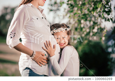little girl and her happy pregnant mom on a walk in the summer Park little girl and her happy pregnant mom on a walk in the summer Park 100060269