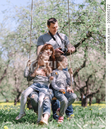 Happy family resting in the spring garden. Happy family resting in the spring garden. 100060272
