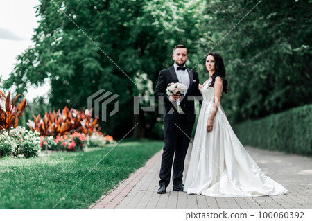 bride and groom standing on the path in the city Park 100060392