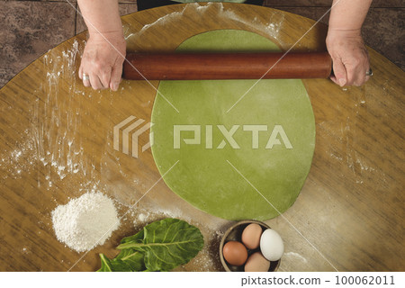 Grandma's hands kneading, dough for green noodles. Grandma's hands kneading, dough for green noodles. 100062011