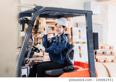 Female worker operating heavy machinery Female worker operating heavy machinery 100062431
