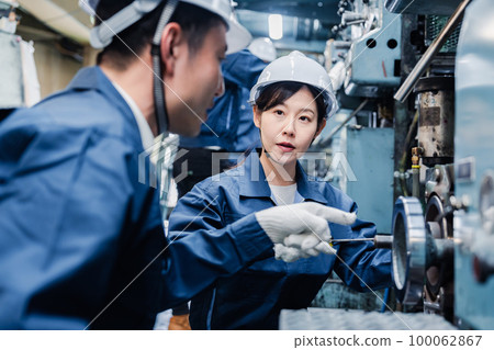 Foreign workers being taught how to work at a factory 100062867