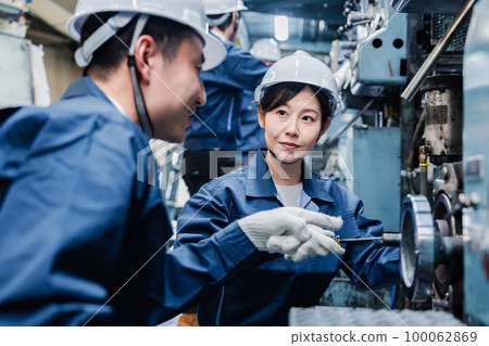 Foreign workers being taught how to work at a factory 100062869