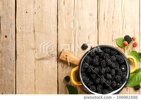 Fresh blackberries in little pan on planks background 100062880