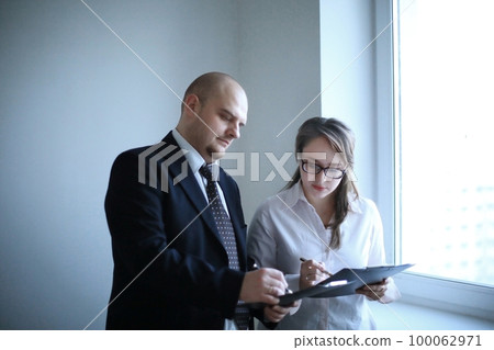 surprised businessman and assistant discussing business documents 100062971