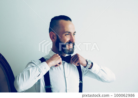 close up. smiling man straightening his bow tie 100062986