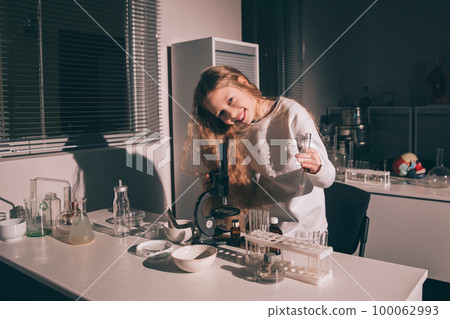 girl schoolgirl standing near the table in the chemistry room girl schoolgirl standing near the table in the chemistry room 100062993