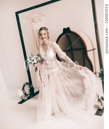 happy bride in boudoir dresses hotel room. happy bride in boudoir dresses hotel room. 100063019