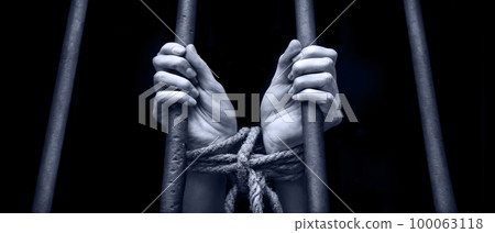 Tied woman hands behind bars 100063118