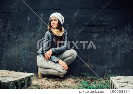 sad young woman sitting near black wall sad young woman sitting near black wall 100063184