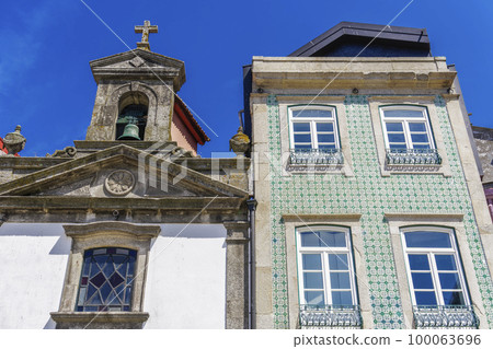 Porto, Portugal Ribeira church next to a house. Day view of facade with house with traditional Portuguese Azulejo tiles. Porto, Portugal Ribeira church next to a house. Day view of facade with house with traditional Portuguese Azulejo tiles. 100063696