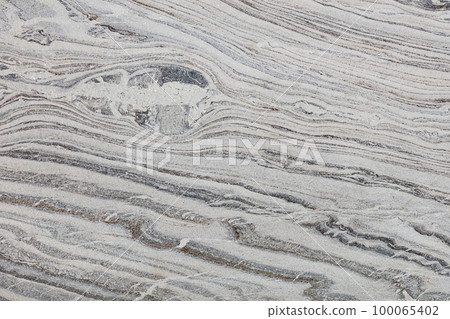The texture of a stone polished surface with beautiful diagonal waves of relief pattern. The texture of a stone polished surface with beautiful diagonal waves of relief pattern. 100065402
