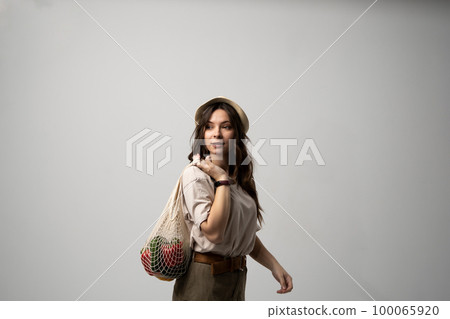 Young woman holding mesh grocery bag with vegetables Concept of no plastic. Zero waste, plastic free. Eco friendly concept. Sustainable lifestyle. 100065920