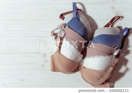 Set of colorful bra on wooden background, closeup. 100068221