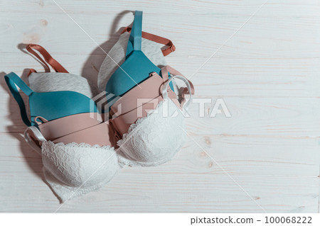 Set of colorful bra on wooden background, closeup. 100068222