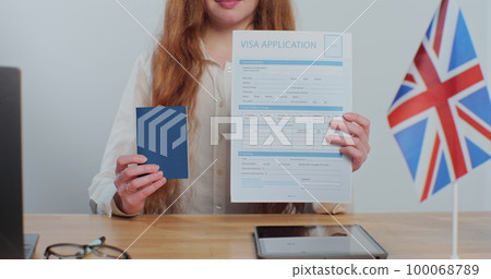 British embassy woman officer showing visa application and passport, legal immigration, tourist interview. British embassy woman officer showing visa application and passport, legal immigration, tourist interview. 100068789