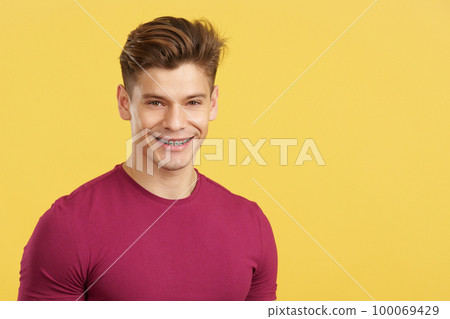 Caucasian man smiling while wearing brackets on his teeth 100069429