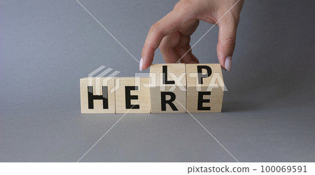 Help is here symbol. Businessman hand Turnes cubes and changes word Here to Help. Beautiful grey background. Business and Help is here concept. Copy space Help is here symbol. Businessman hand Turnes cubes and changes word Here to Help. Beautiful grey background. Business and Help is here concept. Copy space 100069591