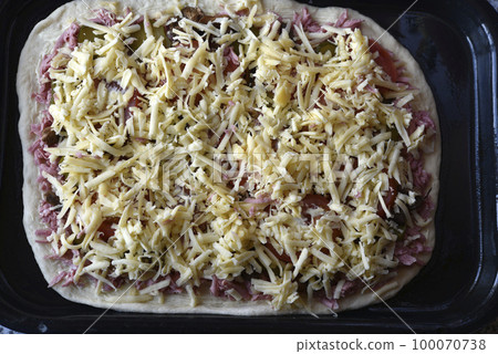 Cooking pizza at home. Raw pizza dough. Meat pizza. 100070738