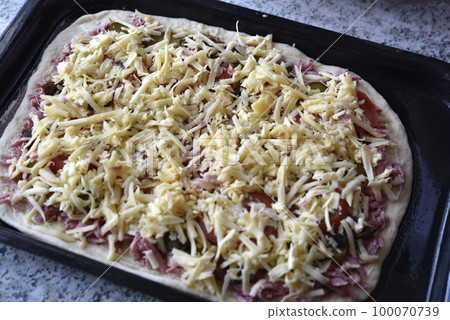 Cooking pizza at home. Raw pizza dough. Meat pizza. Cooking pizza at home. Raw pizza dough. Meat pizza. 100070739