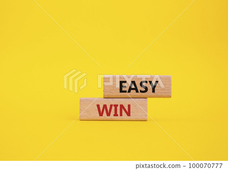 Easy win symbol. Wooden blocks with words Easy win. Beautiful yellow background. Business and 'Easy win' concept. Copy space. Easy win symbol. Wooden blocks with words Easy win. Beautiful yellow background. Business and 'Easy win' concept. Copy space. 100070777