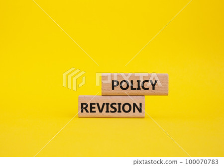 Policy revision symbol. Concept word Policy revision on wooden blocks. Beautiful yellow background. Business and Policy revision concept. Copy space 100070783