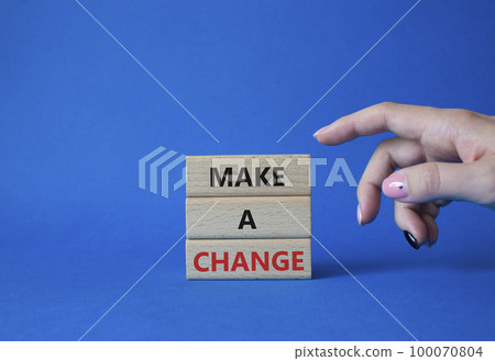 Make a change symbol. Concept words Make a change on wooden blocks. Beautiful blue background. Businessman hand. Business and Make a change concept. Copy space. 100070804
