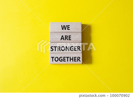 We are stronger together symbol. Wooden blocks with words We are stronger together. Beautiful yellow background. We are stronger together concept. Copy space. 100070902