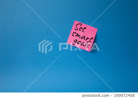 Set smart goals symbol. Concept words Set smart goals on pink steaky note. Beautiful blue background. Business and Set smart goals concept. Copy space. 100072488
