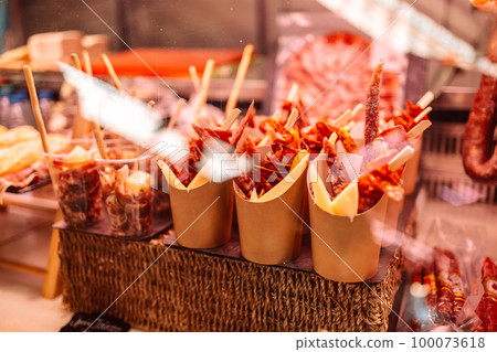 Traditional spanish chorizo, jamon and cheese snacks for takeaway on the famous market at Barcelona, Catalonia, Spain. Traditional spanish chorizo, jamon and cheese snacks for takeaway on the famous market at Barcelona, Catalonia, Spain. 100073618