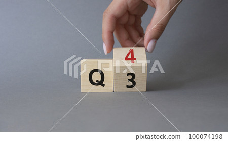 From 3rd Quarter to 4th symbol. Businessman hand Turnes cube and changes words 3rd Quarter to 4th Quarter. Beautiful grey background. Business and Quarter concept. Copy space 100074198