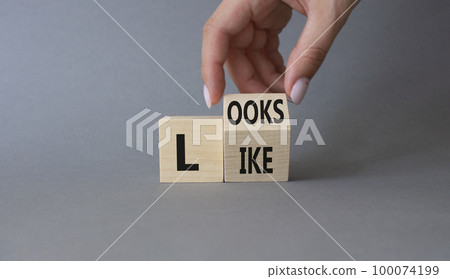 Looks like symbol. Businessman hand Turnes cubes with words Looks like. Beautiful grey background. Business and Looks like concept. Copy space 100074199