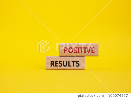 Positive results symbol. Concept words 'Positive results' on wooden blocks. Beautiful yellow background. Business and Positive results concept. Copy space. 100074257
