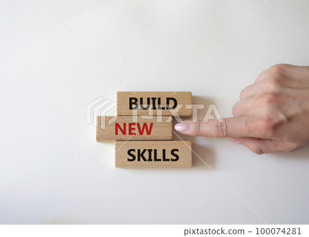 Build New skills symbol. Concept word Build New skills on wooden blocks. Businessman hand. Beautiful white background. Business and Build New skills concept. Copy space Build New skills symbol. Concept word Build New skills on wooden blocks. Businessman hand. Beautiful white background. Business and Build New skills concept. Copy space 100074281