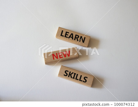 Learn new skills symbol. Concept words Learn new skills on wooden blocks. Beautiful white background. Business and Learn new skills concept. Copy space. 100074312
