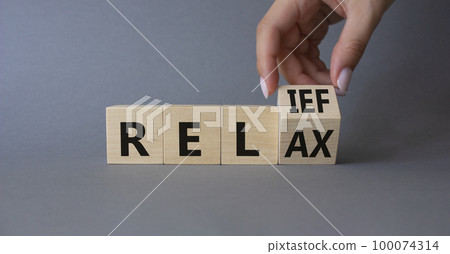 Relief and relax symbol. Hand turns cubes and changes the word Relief to Relax. Beautiful grey background. Businessman hand. Business and Relief and relax concept. Copy space Relief and relax symbol. Hand turns cubes and changes the word Relief to Relax. Beautiful grey background. Businessman hand. Business and Relief and relax concept. Copy space 100074314