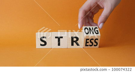 Strong Stress symbol. Businessman Hand turns cubes with words Strong Stress. Beautiful orange background. Business and Strong Stress concept. Copy space 100074322