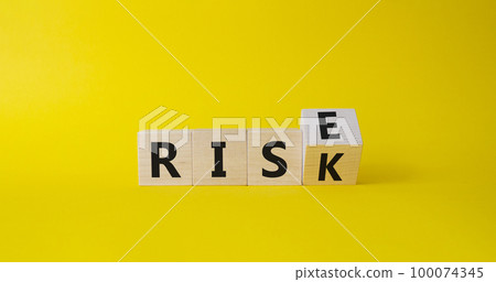 Rise vs Risk symbol. Turned wooden cubes with words Risk vs Rise. Beautiful yellow background. Businessman hand. Business and Rise vs Risk concept. Copy space 100074345