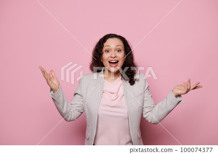 Isolated portrait on pink color background of a multi-ethnic amazed pretty woman, gesturing with hands, looking at camera with surprised amazed look, expressing positive emotions. People and Lifestyle Isolated portrait on pink color background of a multi-ethnic amazed pretty woman, gesturing with hands, looking at camera with surprised amazed look, expressing positive emotions. People and Lifestyle 100074377